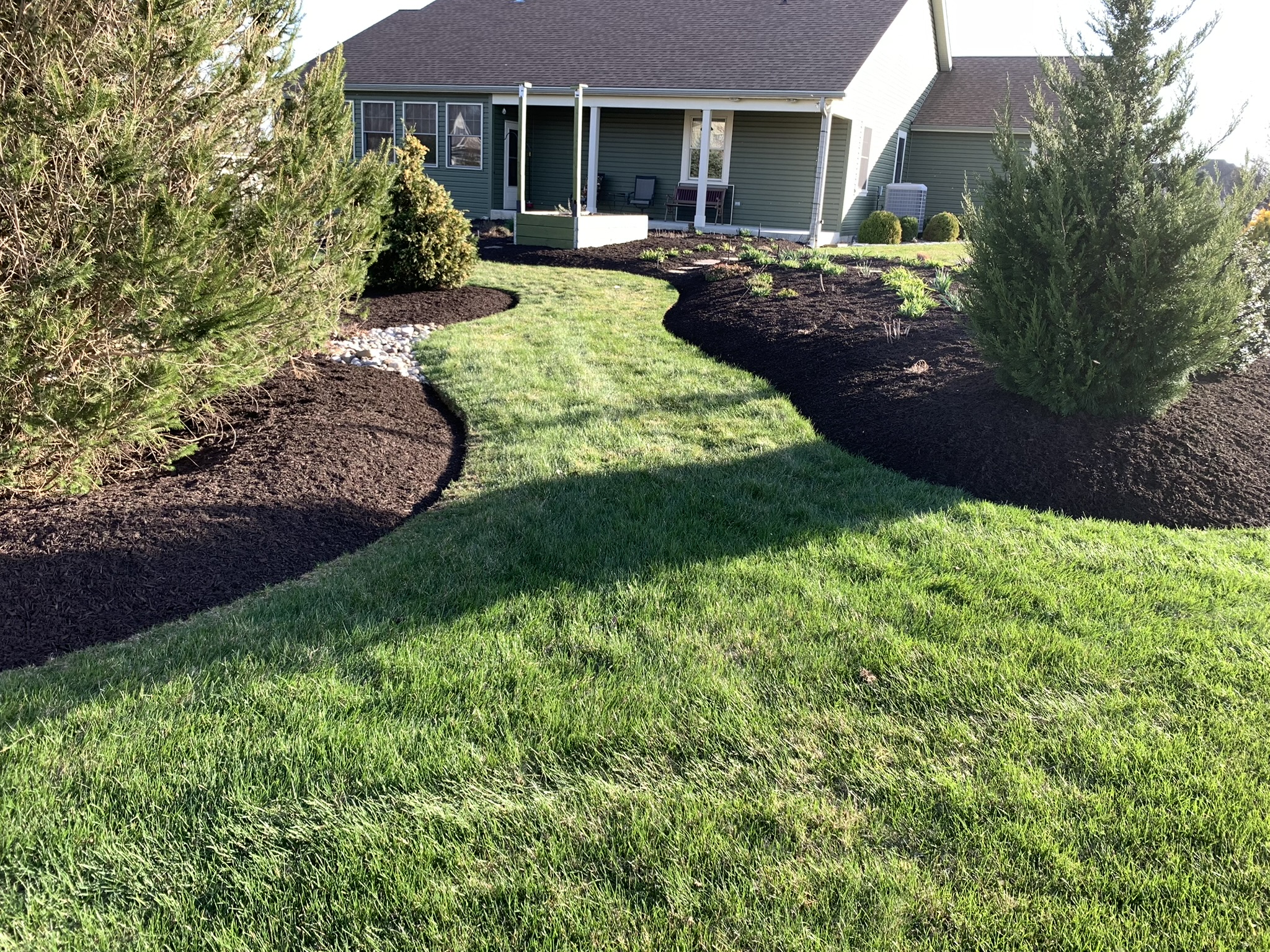 Freshly cleaned foundation beds with dark mulch, crisp edging, and a maintained lawn in Lehighton, PA
