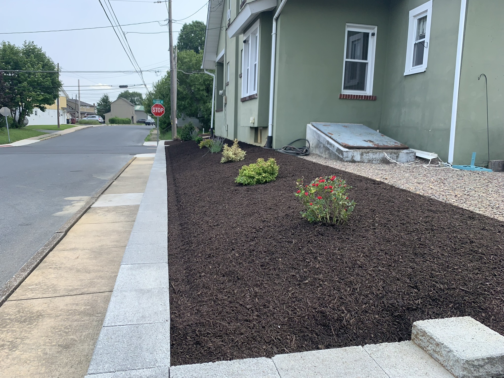 After landscaping cleanup with fresh mulch, crisp bed lines, and a maintained lawn